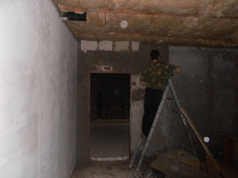 Čáp dodělává poslední kousek jádrové omítky v malé klubovně